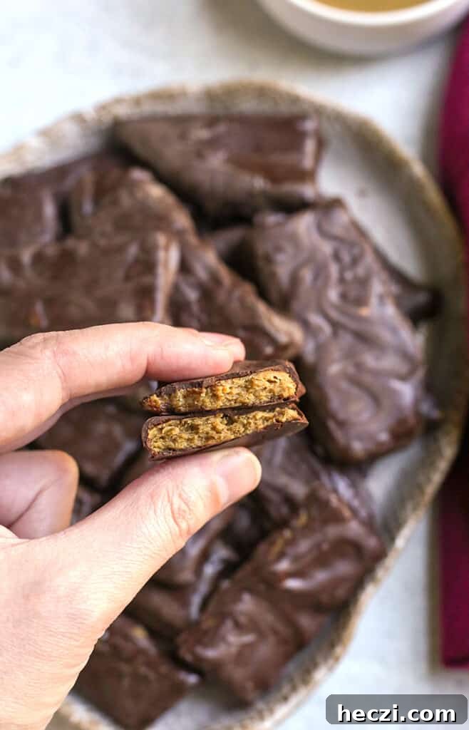 a hand holding a paleo vegan butterfinger candy bar, showing the inside