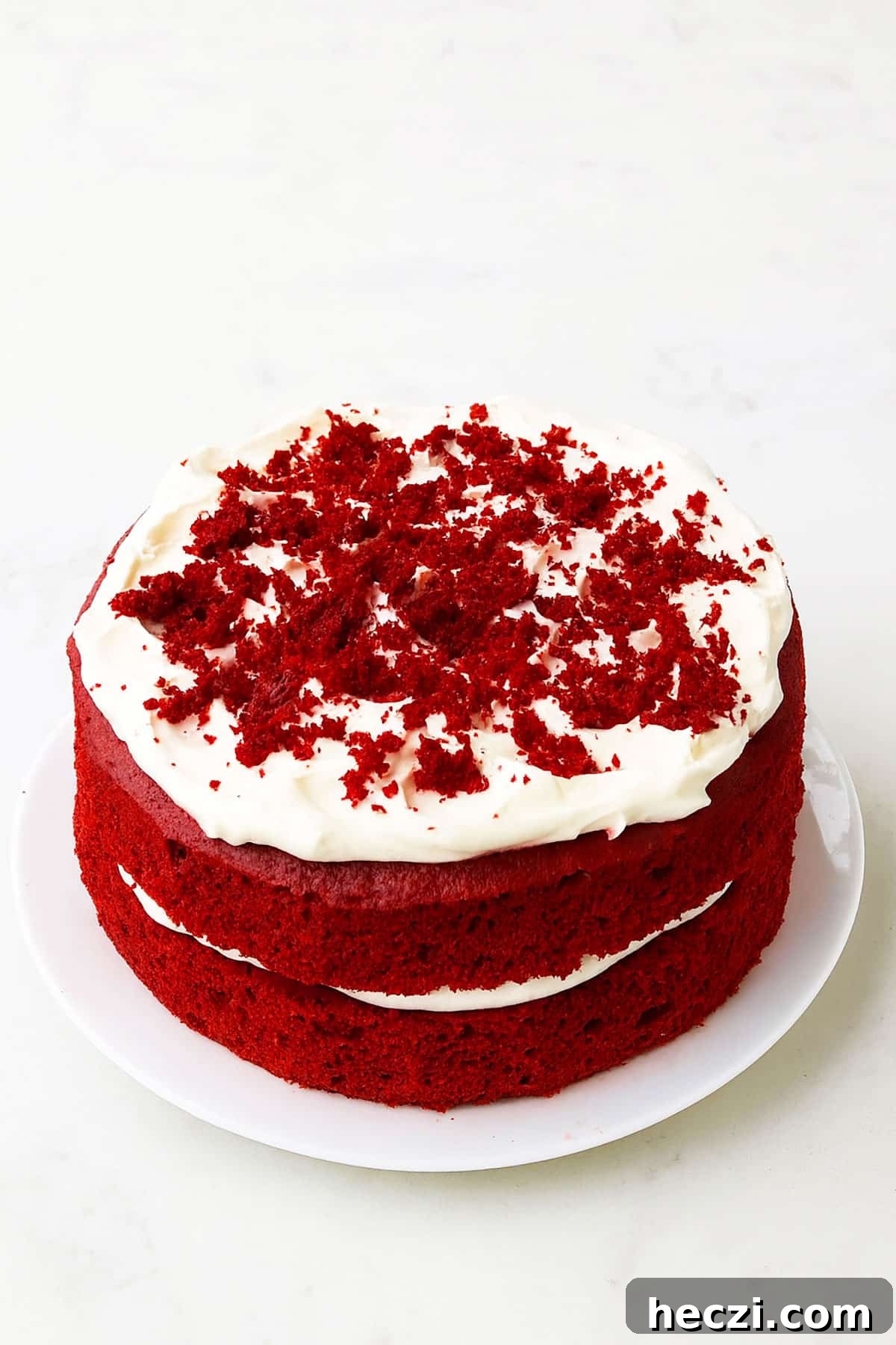 Moist Red Velvet Layer Cake Recipe for Perfect Celebrations 2 Best easy soft and moist red velvet cake (layer cake) with cream cheese frosting on white dish.