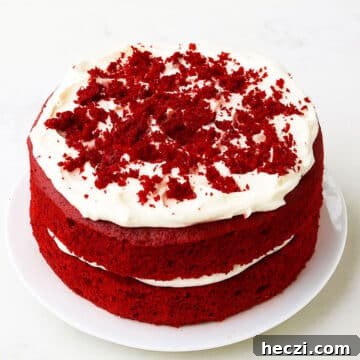 Best easy soft and moist red velvet cake (layer cake) with cream cheese frosting on white dish and white background.