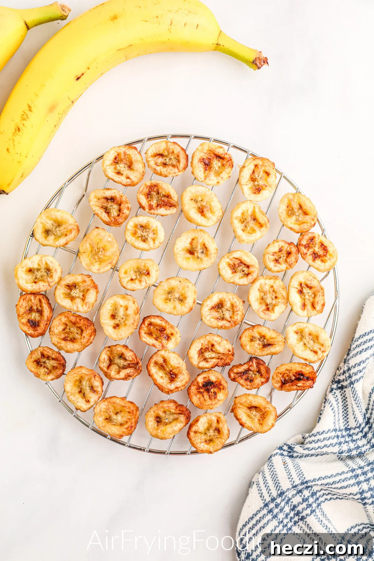 Crispy Air Fryer Banana Chips Recipe — Quick Snack at Home 8 Banana Chips on a wire rack cooling after being air fried.