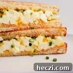 egg salad sandwich sliced in half and stacked close up right