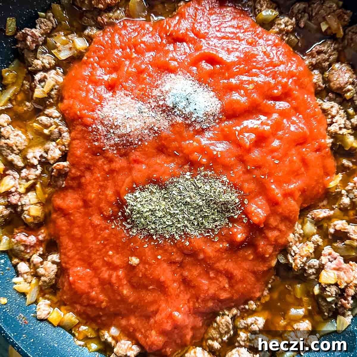 Slow Cooker Lamb Ragu: Tender Rustic Pasta Sauce Recipe 12 Crushed tomatoes, salt, and Italian spices are added to the lamb mixture in the frying pan.