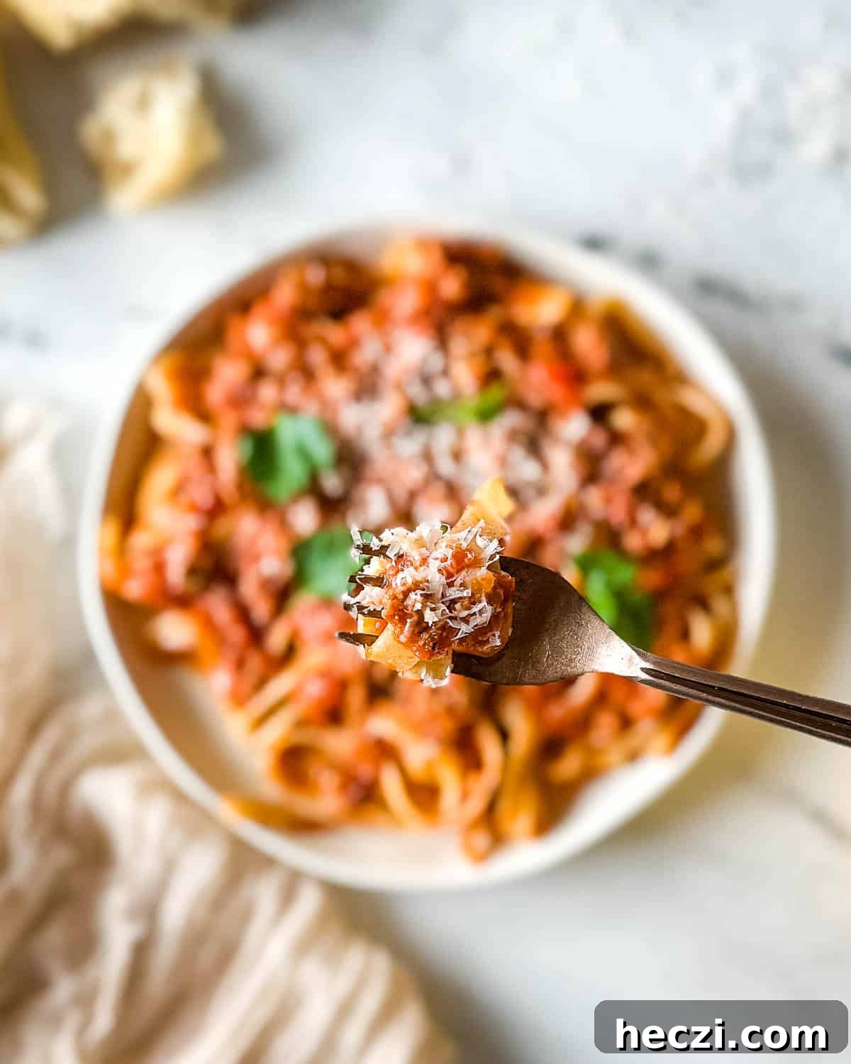 Slow Cooker Lamb Ragu: Tender Rustic Pasta Sauce Recipe 16 Closeup of pappardelle pasta twirled on a forked and coated with lamb ragu over a plate of slow cooker lamb ragu.