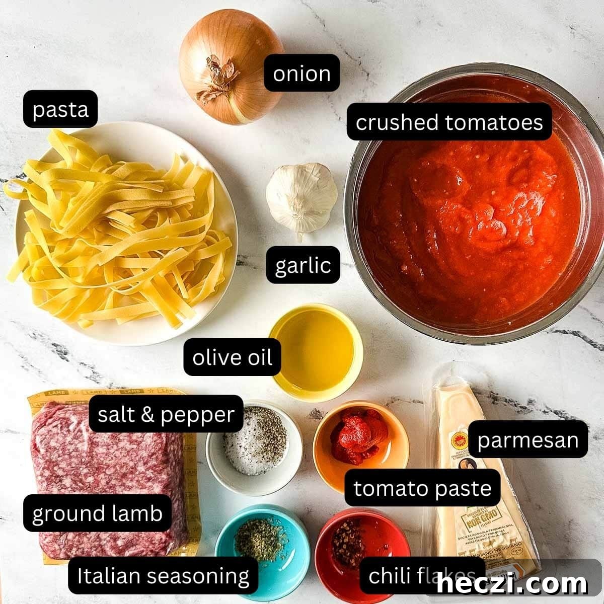 Slow Cooker Lamb Ragu: Tender Rustic Pasta Sauce Recipe 3 labeled ingredients for slow cooker lamb ragu on a white marble counter.