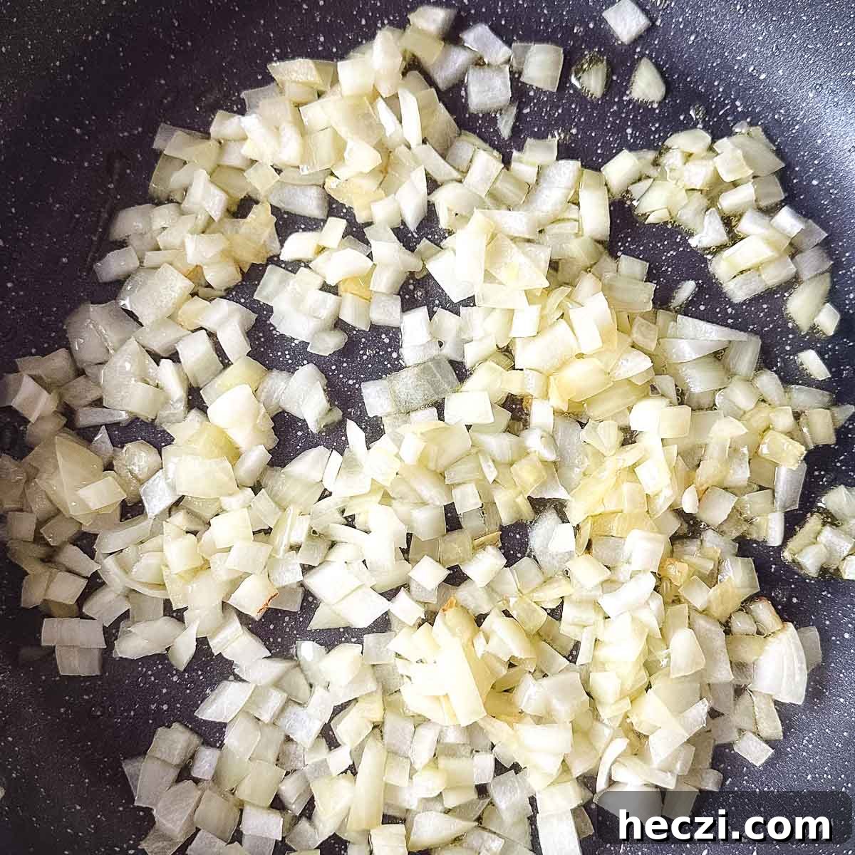 Slow Cooker Lamb Ragu: Tender Rustic Pasta Sauce Recipe 6 chopped onion sweating in a frying pan.