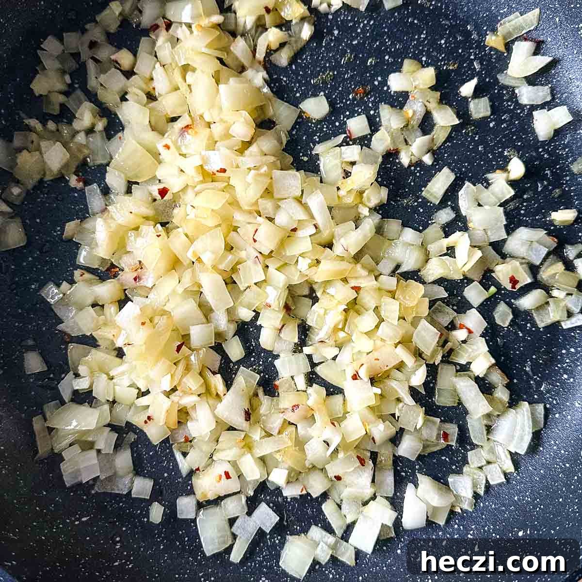 Slow Cooker Lamb Ragu: Tender Rustic Pasta Sauce Recipe 7 garlic and chili flakes are added to the onion sweating in a frying pan.