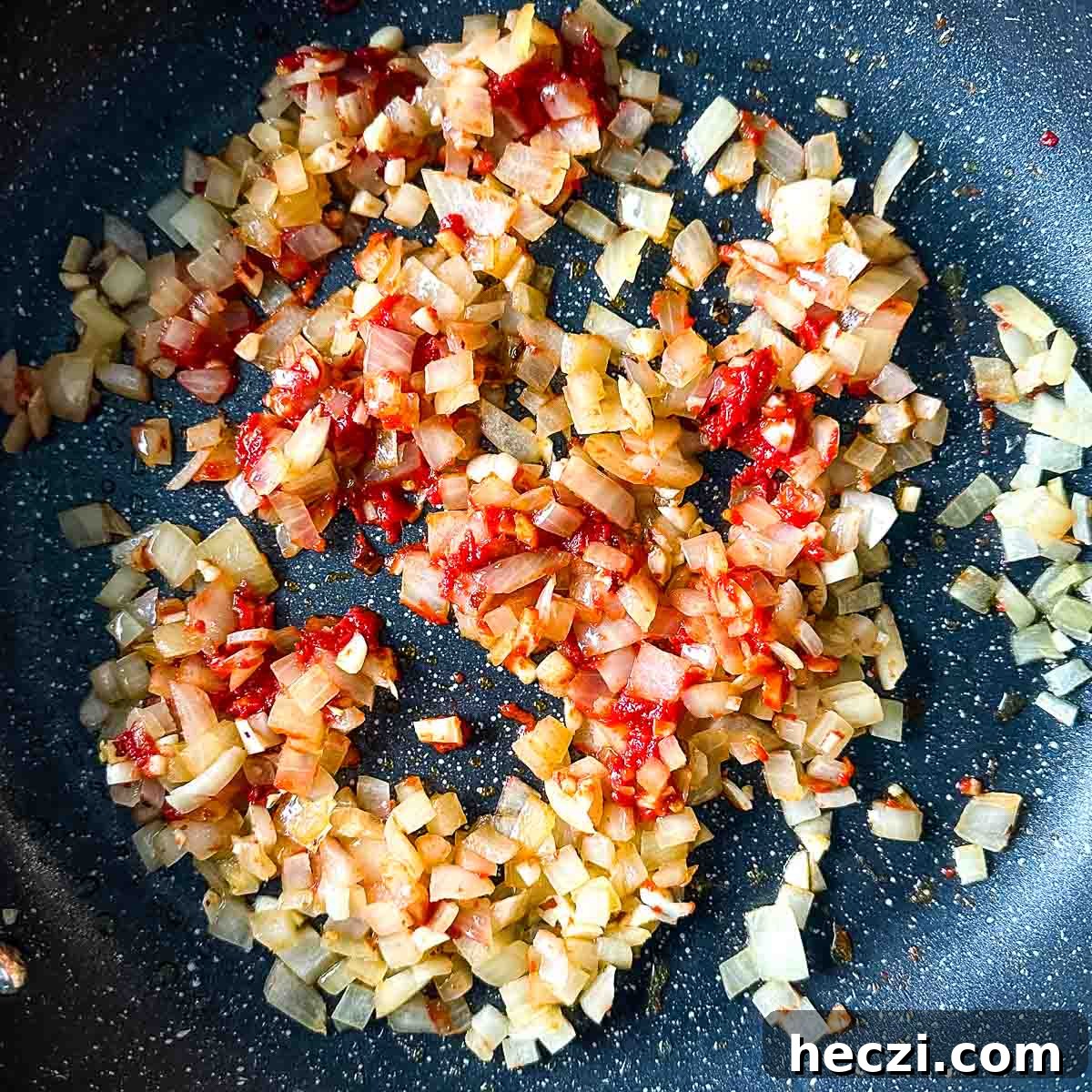 Slow Cooker Lamb Ragu: Tender Rustic Pasta Sauce Recipe 8 tomato paste is added to the frying pan with sweated onion, garlic, and chili flakes.