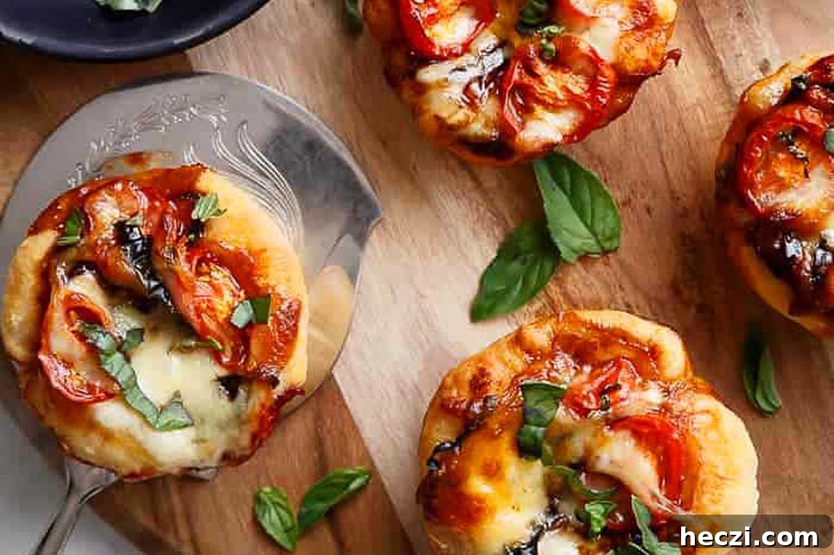Italian appetizers - mini pizzas with tomatoes and basil on a wooden cutting board.