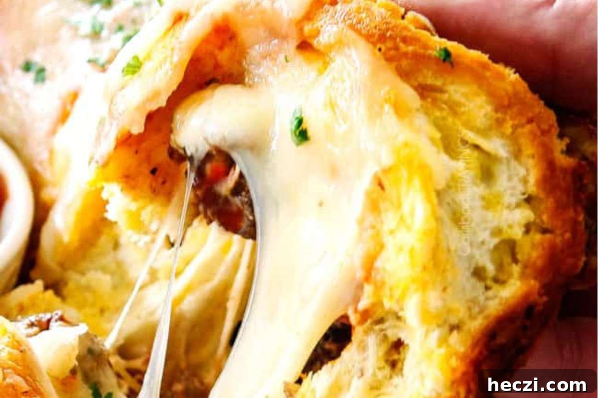 An Italian person savoring a bite out of a cheesy bread appetizer.
