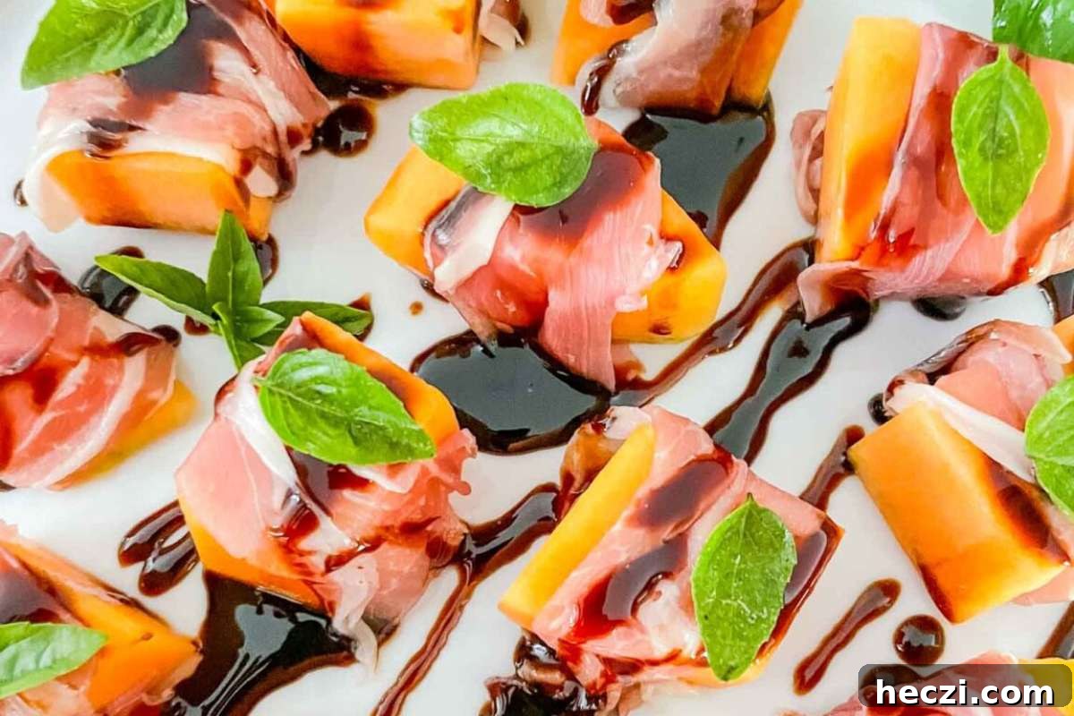 A plate of Italian appetizers with melon and ham, drizzled with a balsamic glaze.