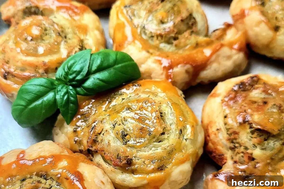 Italian cheesy garlic rolls with basil leaves on a baking sheet, perfect for appetizers.