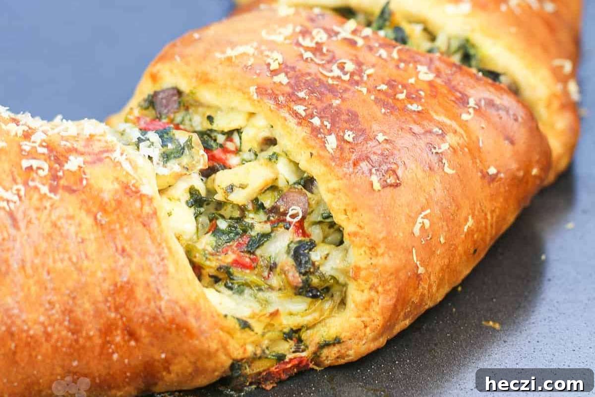 An Italian appetizer featuring a loaf of bread topped with spinach and cheese.