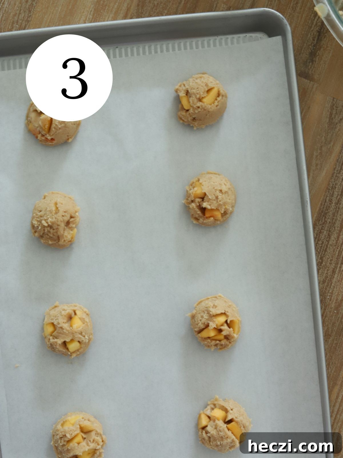Peach Cobbler Cookies Recipe: Soft Peach Jam-Filled Cookies 6 Peach cookie dough balls on a baking sheet lined with parchment paper.