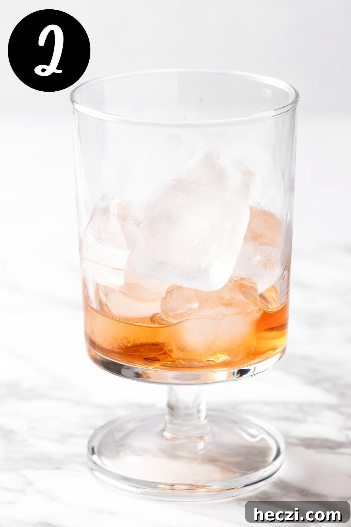 Adding the ice and Southern Comfort to the cocktail glass.