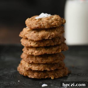 Coconut Oatmeal Cookie Recipe — Chewy Coconut Oatmeal Cookies 10 Close-up of coconut oatmeal cookies stacked with milk in the background.