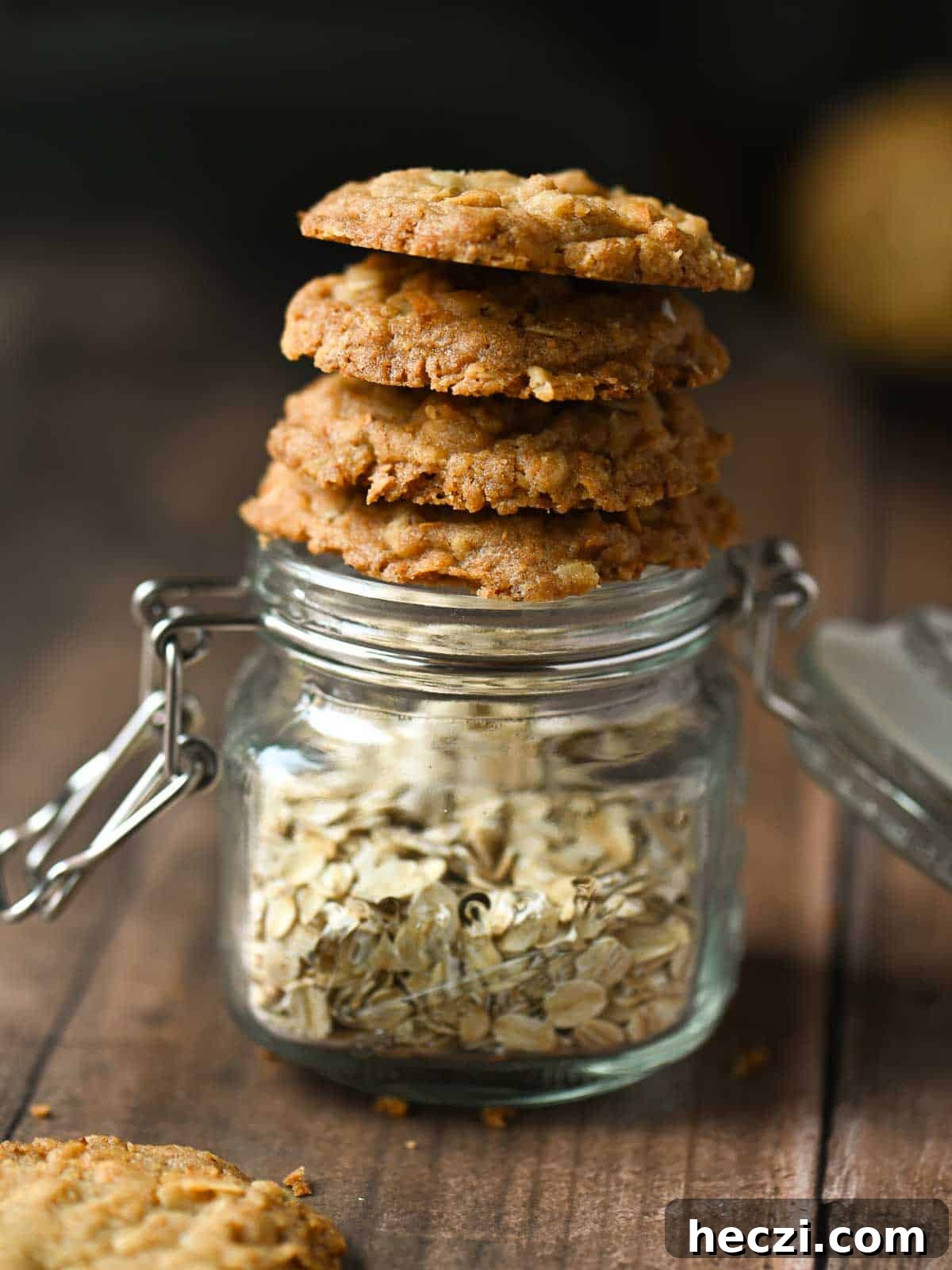 Coconut Oatmeal Cookie Recipe — Chewy Coconut Oatmeal Cookies 3 Cookies stacked on a jar of oatmeal.