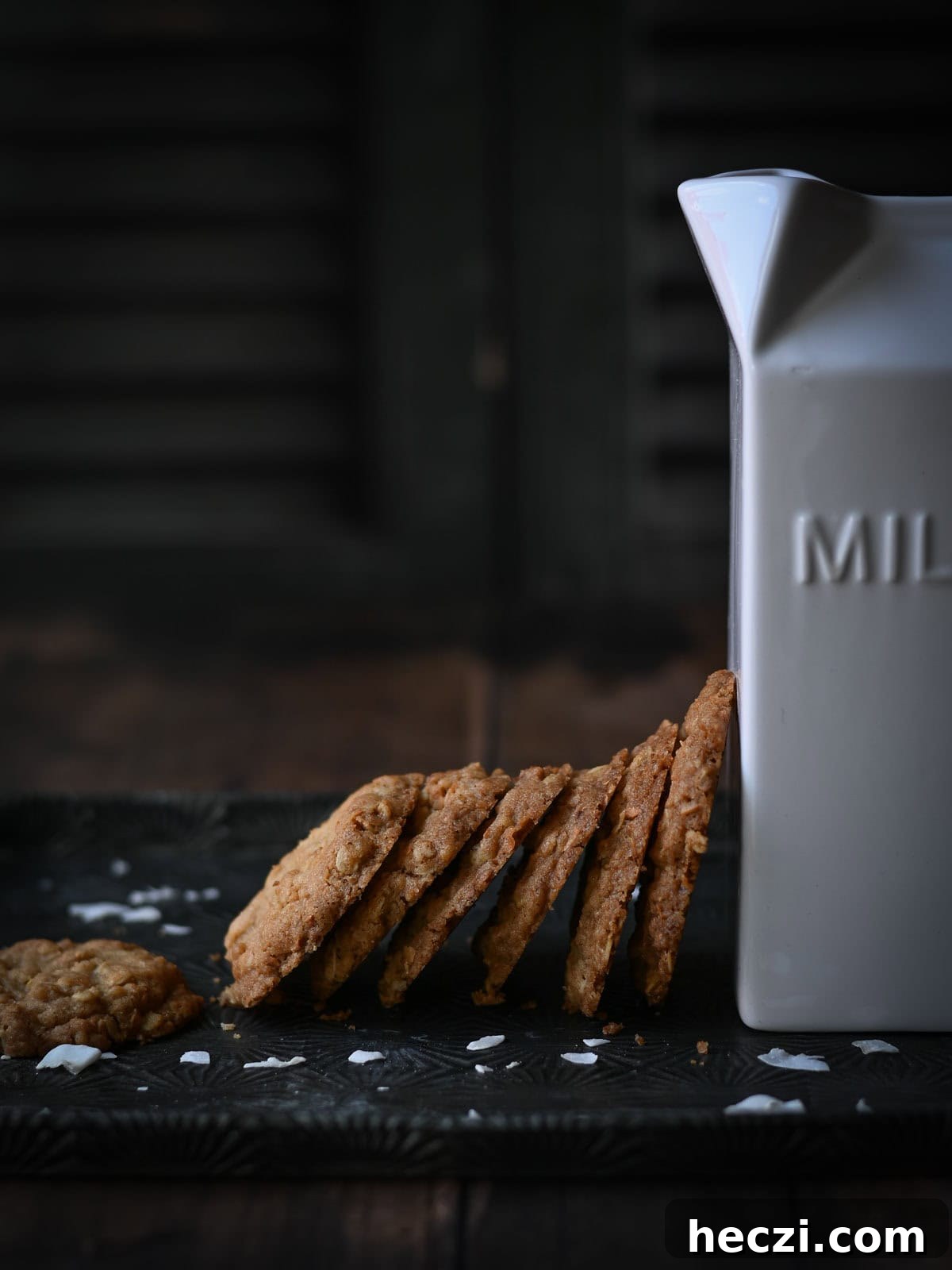 Coconut Oatmeal Cookie Recipe — Chewy Coconut Oatmeal Cookies 9 Coconut cookies leaned up against a white milk carton.