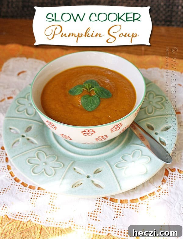 Slow Cooker Creamy Pumpkin Soup Recipe 3 A close up photo of a bowl of pumpkin soup with a spoon on the side.