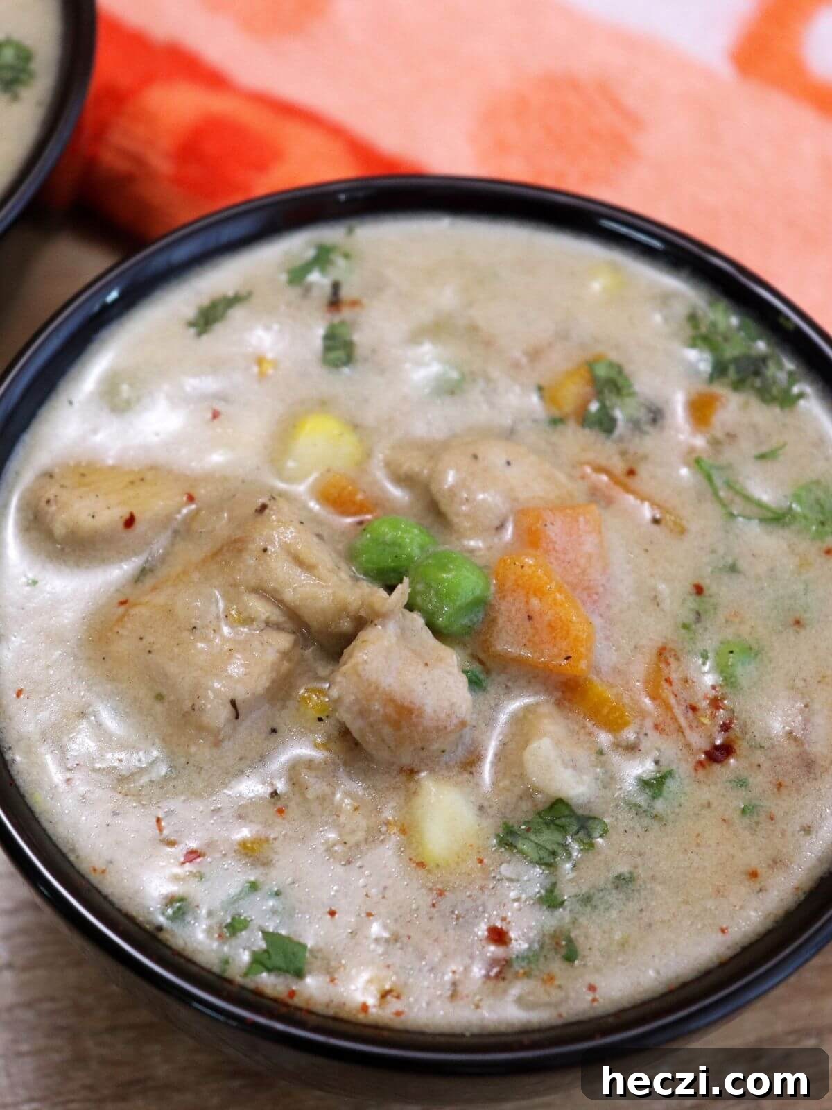 Creamy Chicken and Vegetable Stew for Comforting Weeknight Meals 2 close-up of chicken stew served in a black bowl.