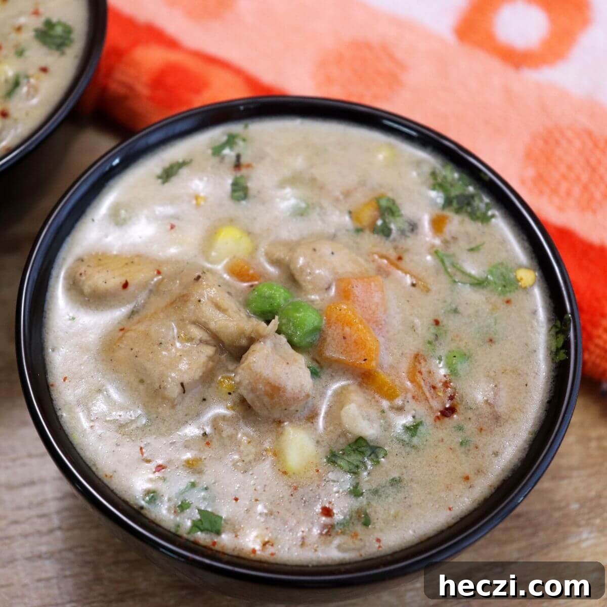 Creamy Chicken and Vegetable Stew for Comforting Weeknight Meals 4 chicken stew served in a black bowl. Garnished with coriander leaves.