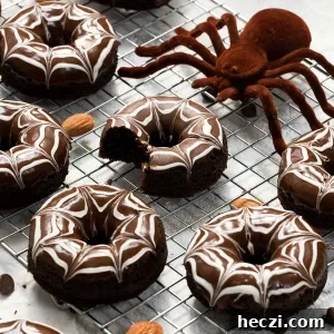 Gluten-free Halloween spiderweb chocolate donuts on a cooling rack with a large spider.