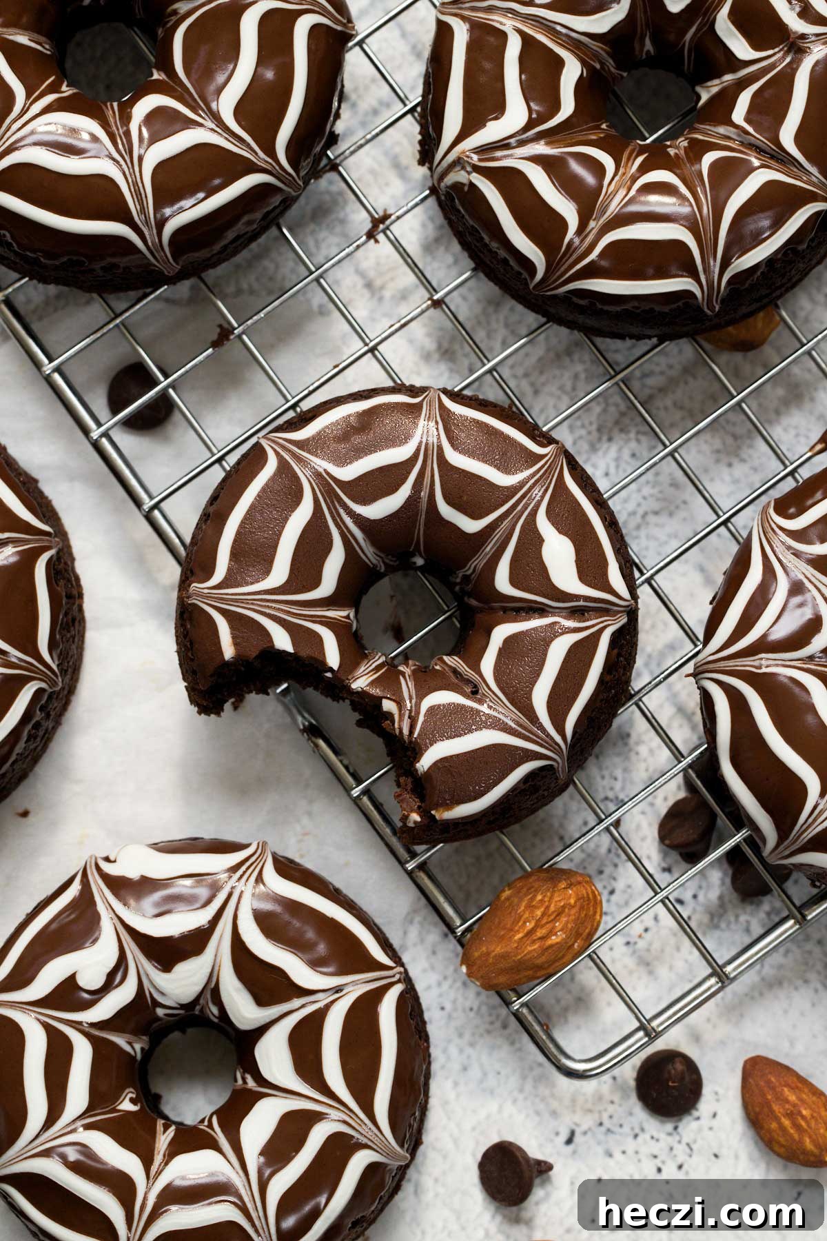 Top view of a baked chocolate donut with white and dark chocolate spiderweb design on top.