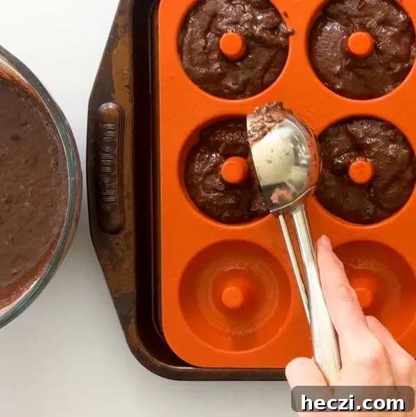 Scooping the donut batter into the silicone donut mold.