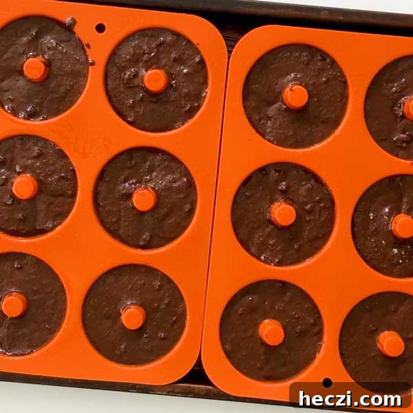Silicone muffin trays filled with donut batter.