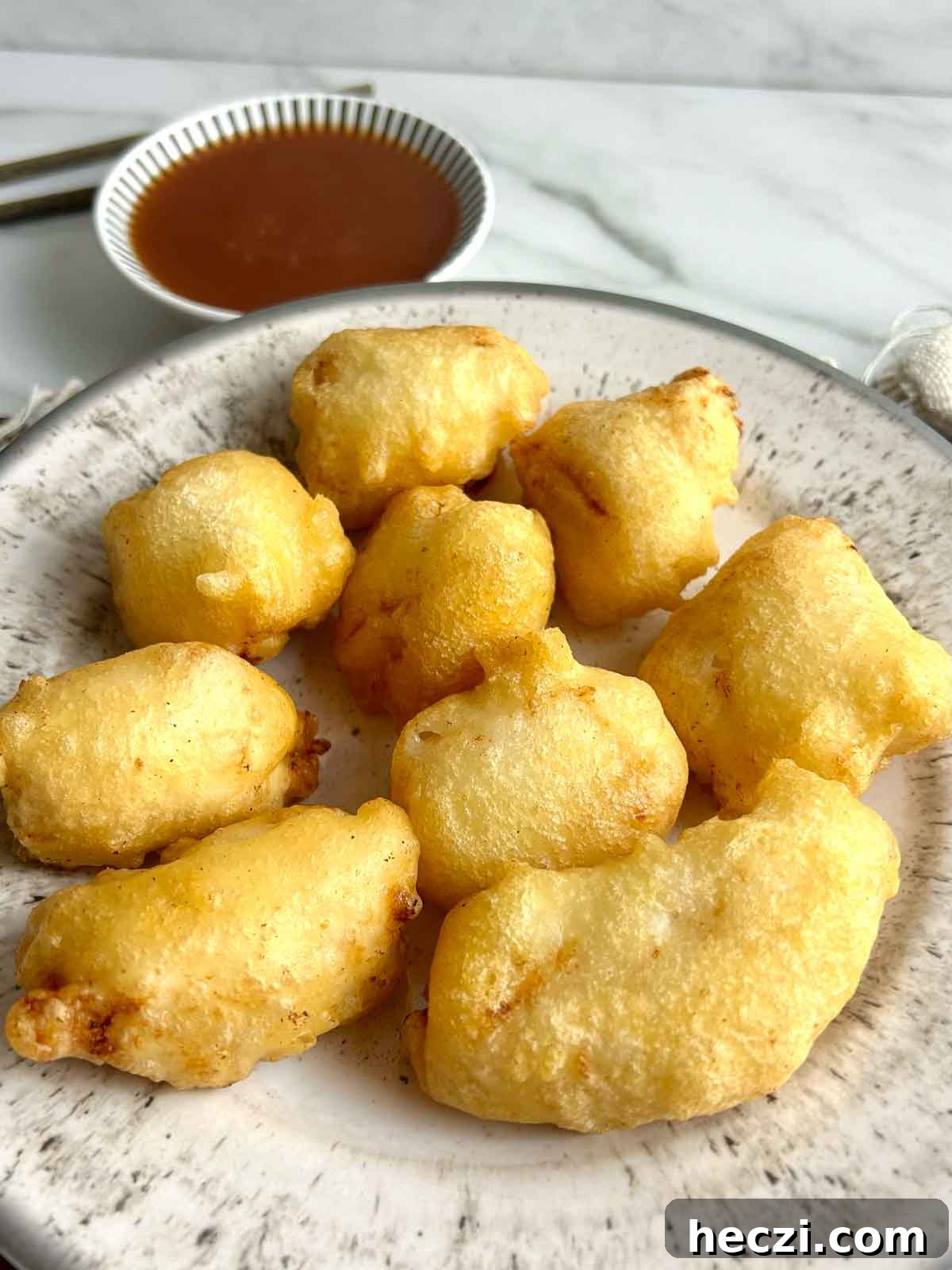 Crispy Chinese Chicken Balls in Classic Sweet and Sour Sauce 11 side view of chicken balls on plate with sweet and sour sauce