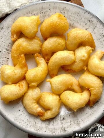 overhead shot of battered prawns on plate with side of sweet and sour sauce