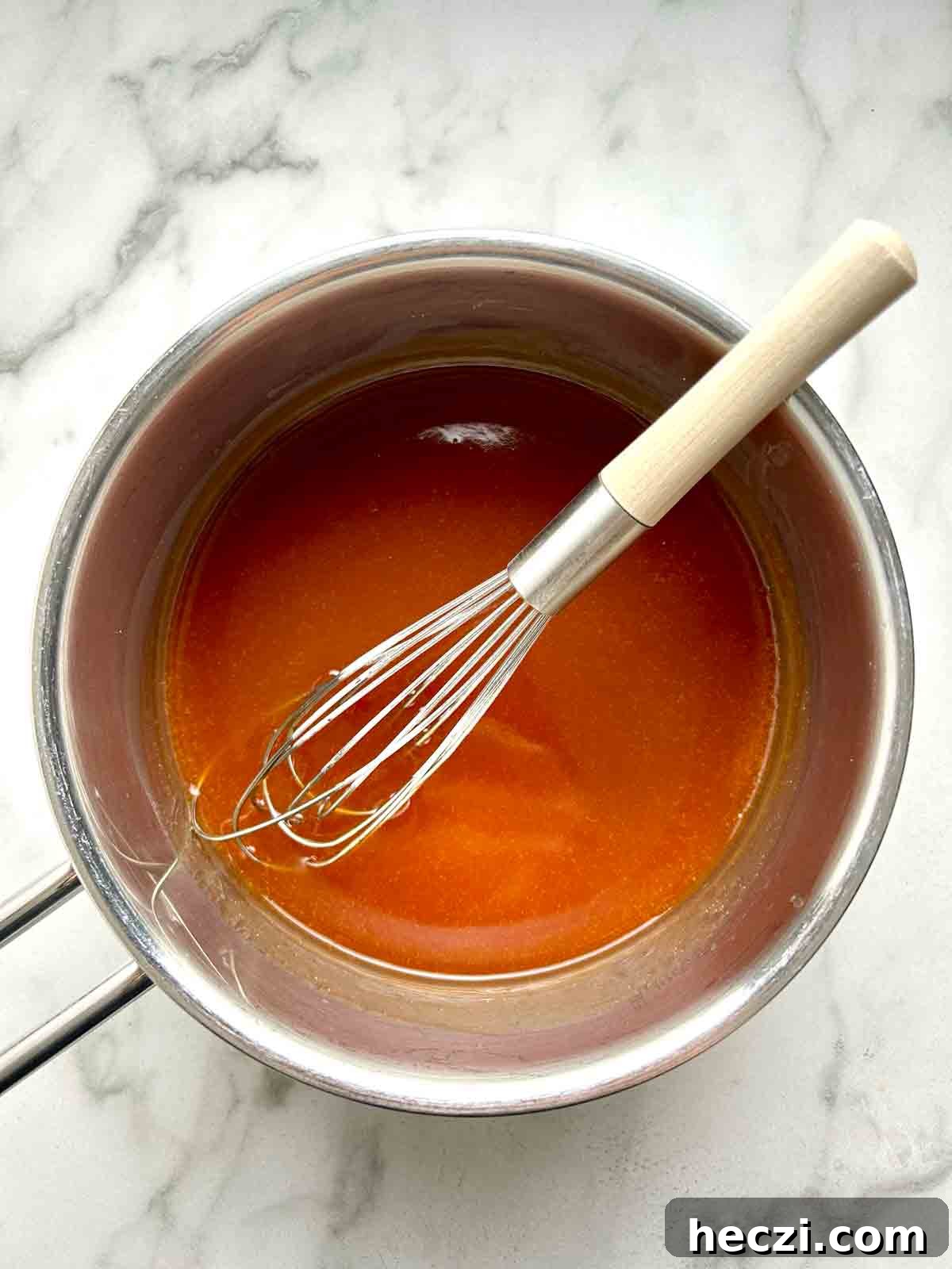 Crispy Chinese Chicken Balls in Classic Sweet and Sour Sauce 10 sweet and sour sauce being whisked in saucepan