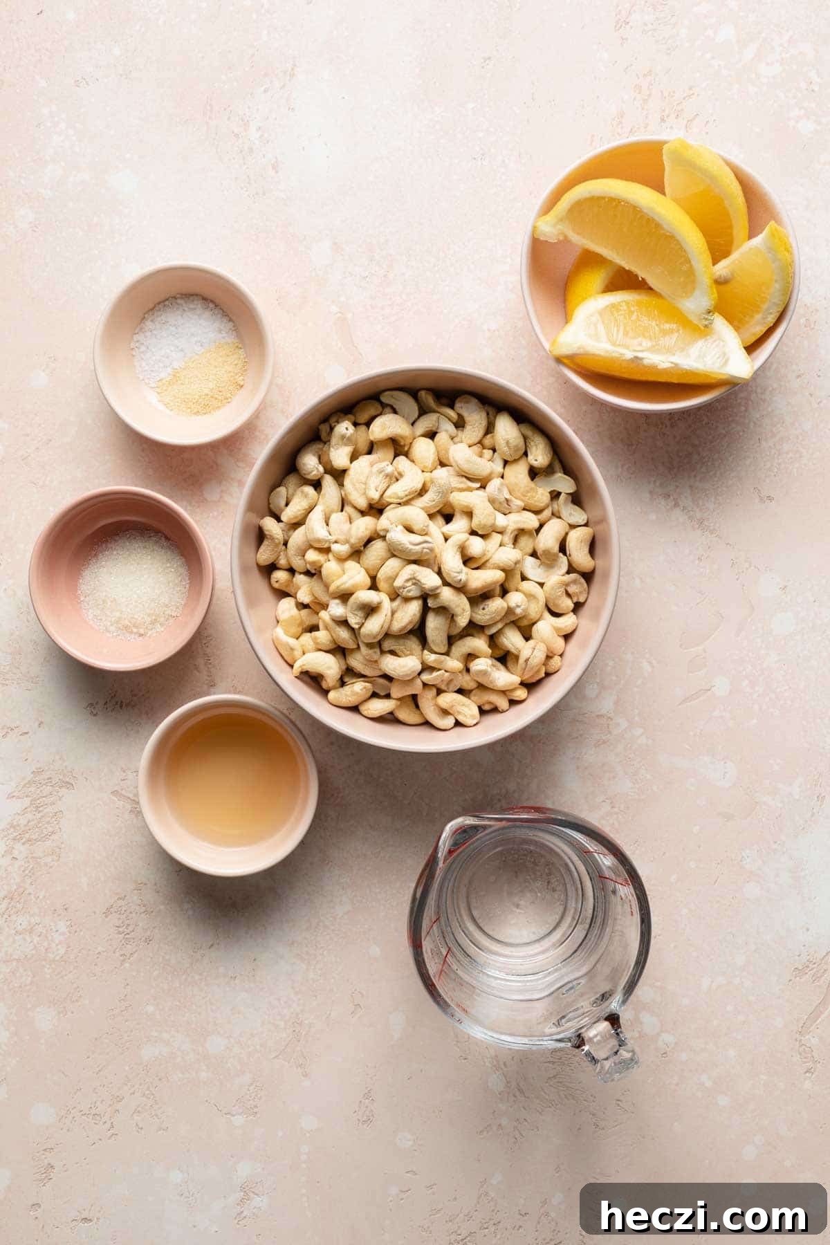 Creamy Cashew Vegan Mayo Recipe — Dairy-Free Mayonnaise 3 Ingredients to make cashew mayo arranged individually on a pink surface.