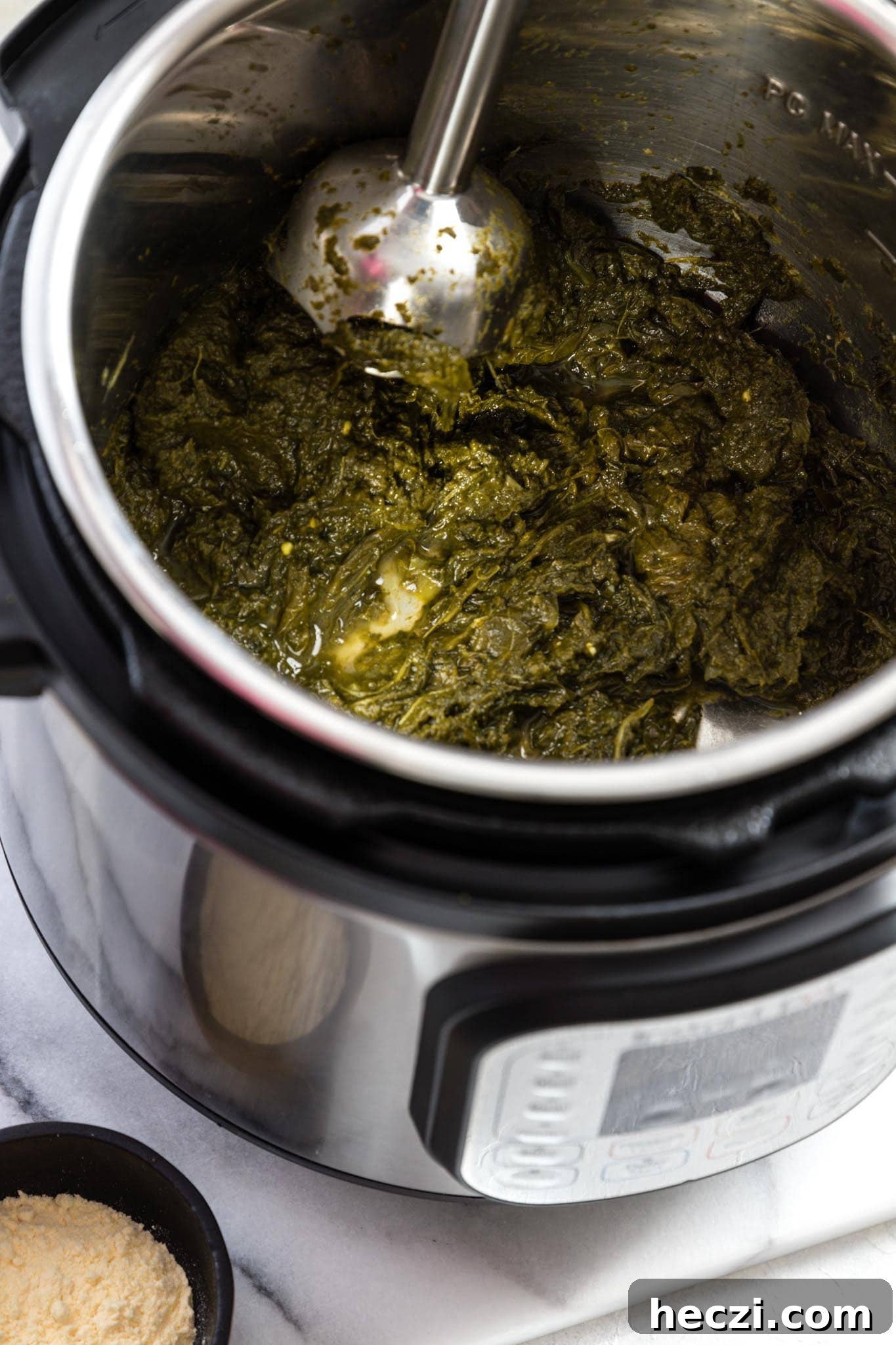 Blending greens for Instant Pot Sarson Ka Saag with a hand blender