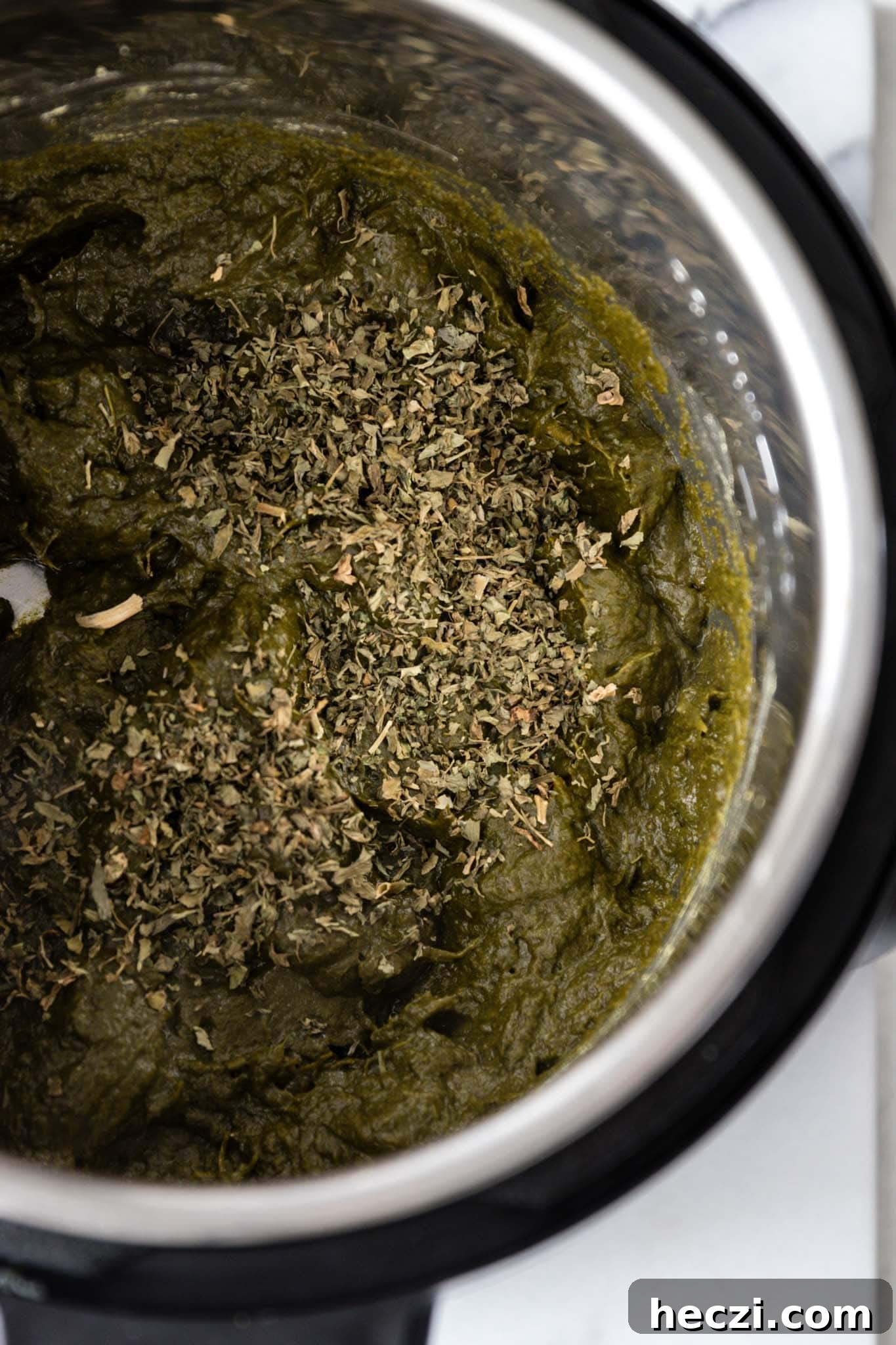 Adding dried fenugreek leaves (methi) to the Instant Pot for Sarson Ka Saag