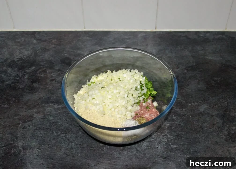 Slow cooker meatballs mixture in a glass bowl unmixed.