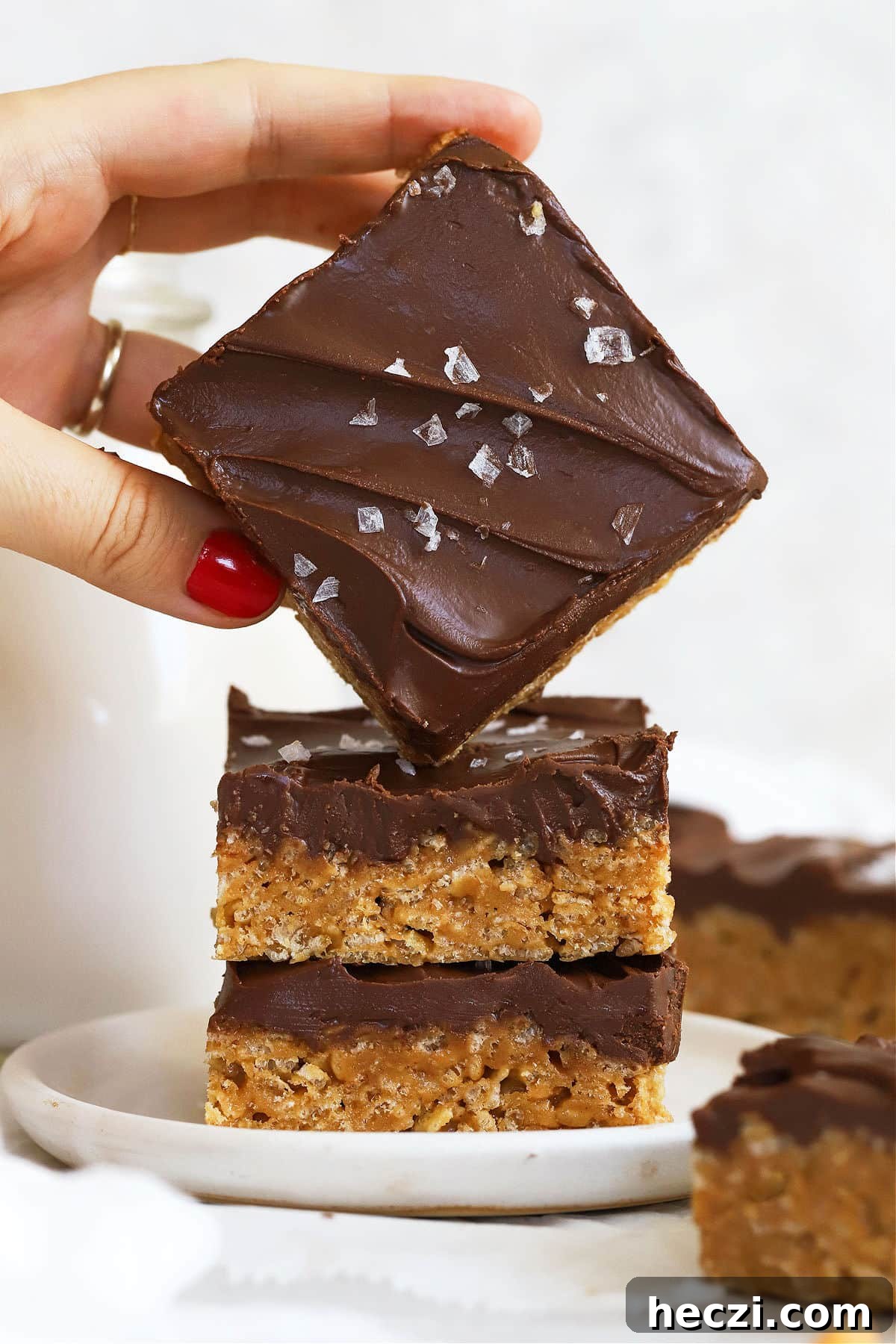 Gluten-Free Scotcheroos Recipe: Chewy Peanut Butter & Butterscotch Bars 7 stacking gluten-free scotcheroos on a white dessert plate