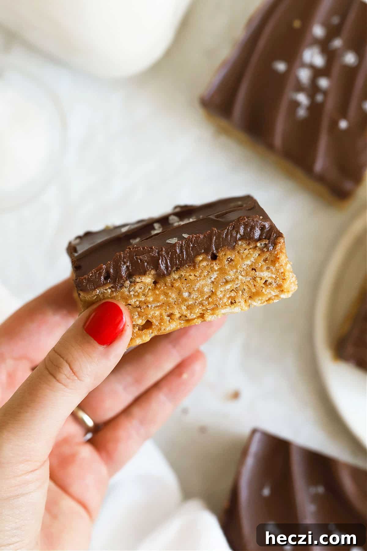 Gluten-Free Scotcheroos Recipe: Chewy Peanut Butter & Butterscotch Bars 8 hand holding up a gluten-free scotcheroo to show the texture