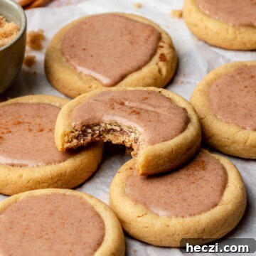 Finished brown sugar pop tart cookies on parchment paper. One has a bite removed.