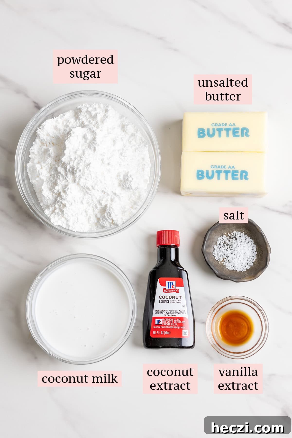 Ingredients for coconut buttercream frosting on a marble surface.