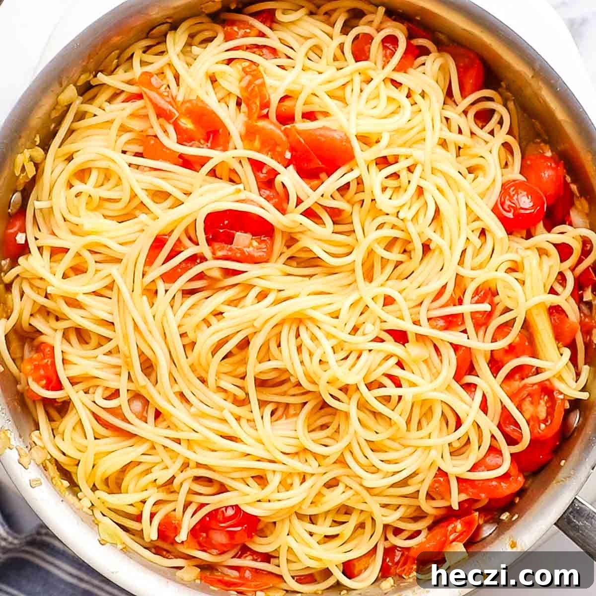 adding spaghetti to the skillet