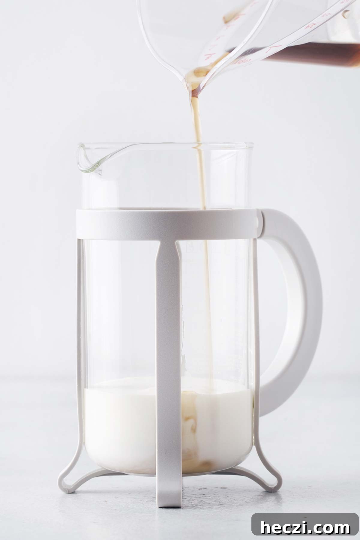 Brown sugar syrup poured into a French press with milk.