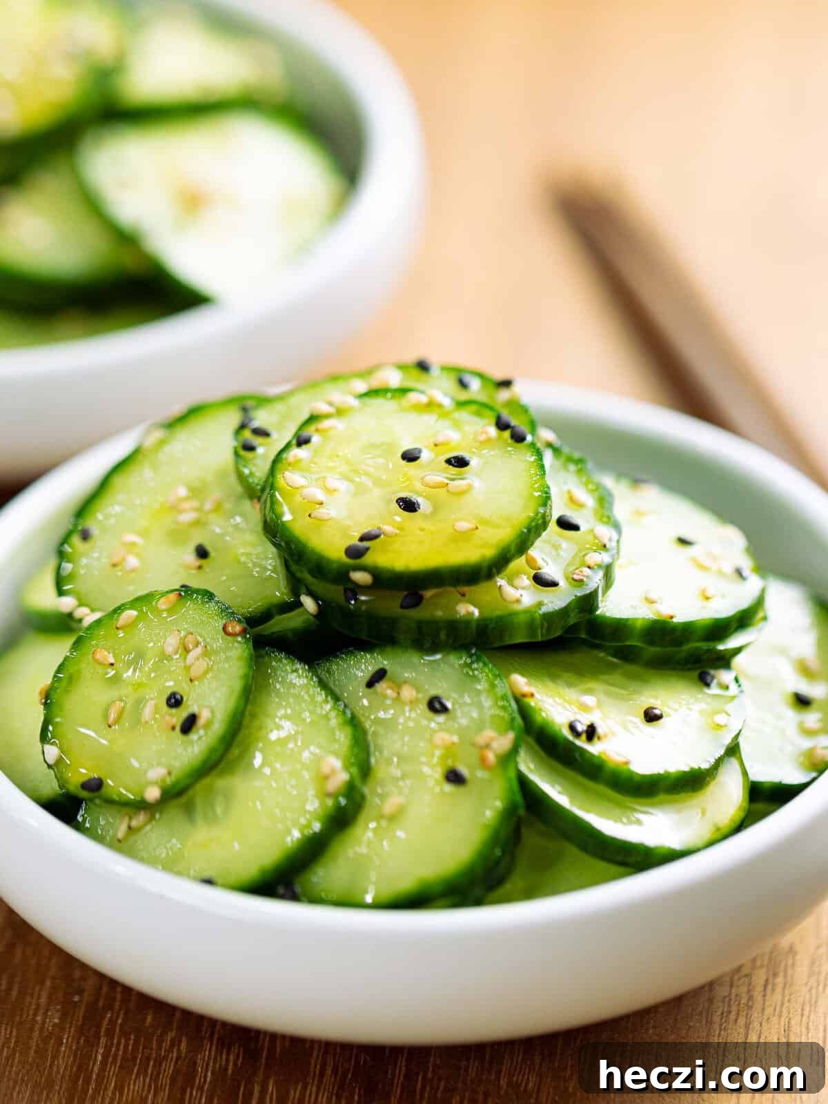 Sunomono or Japanese cucumber salad with sesame seeds in a white bowl.