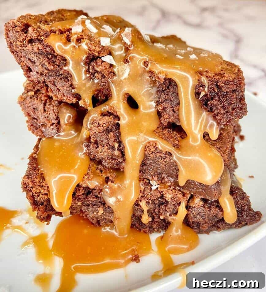 Fudgy Nutella Brownies with Salted Caramel Drizzle 12 Stack of brownies on plate, with caramel sauce oozing down the sides.