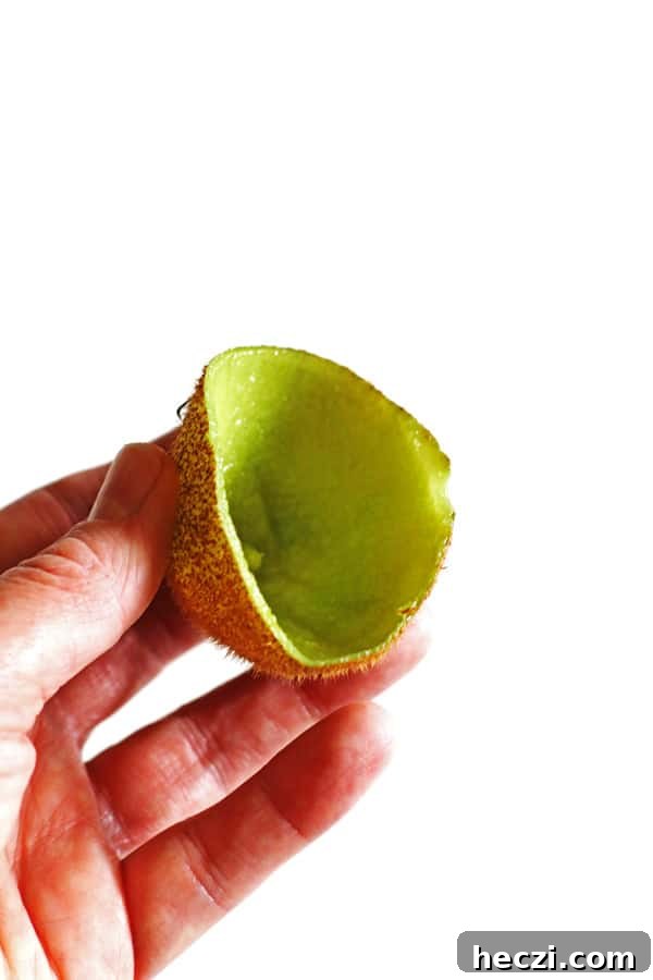 Refreshing Fruit Smoothie Recipes for Energy and Flavor 3 Hand holding the skin of a kiwi