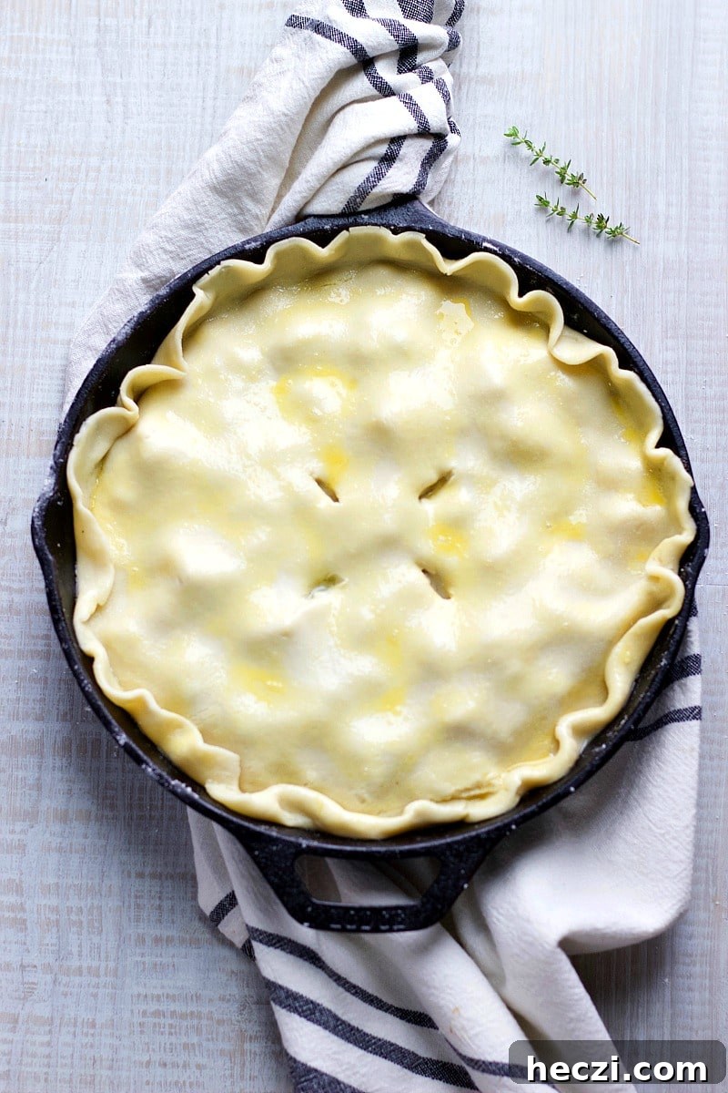 Unbaked skillet Chicken Pot Pie and a white and black dish towel.