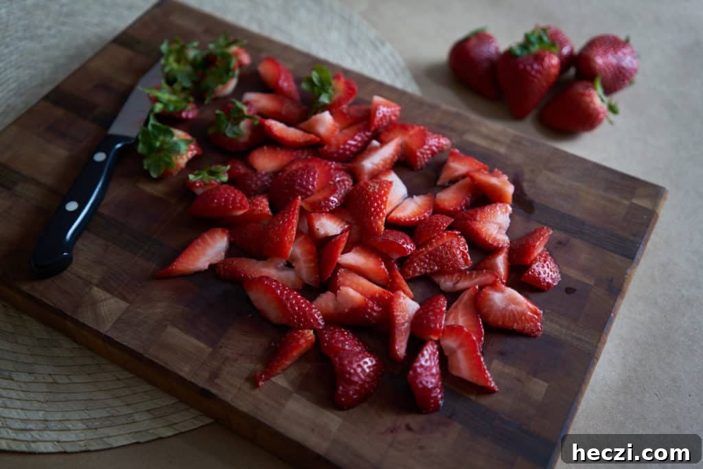 Spring Strawberry and Arugula Salad with Balsamic Glaze 3 Sliced strawberries on a wooden cutting board with a small paring knife.