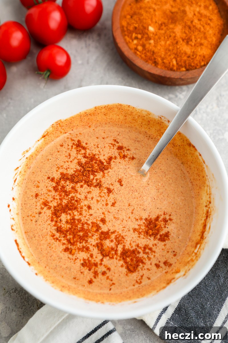 A small white bowl filled with zesty taco dressing made with blue cheese dressing, taco seasoning and water