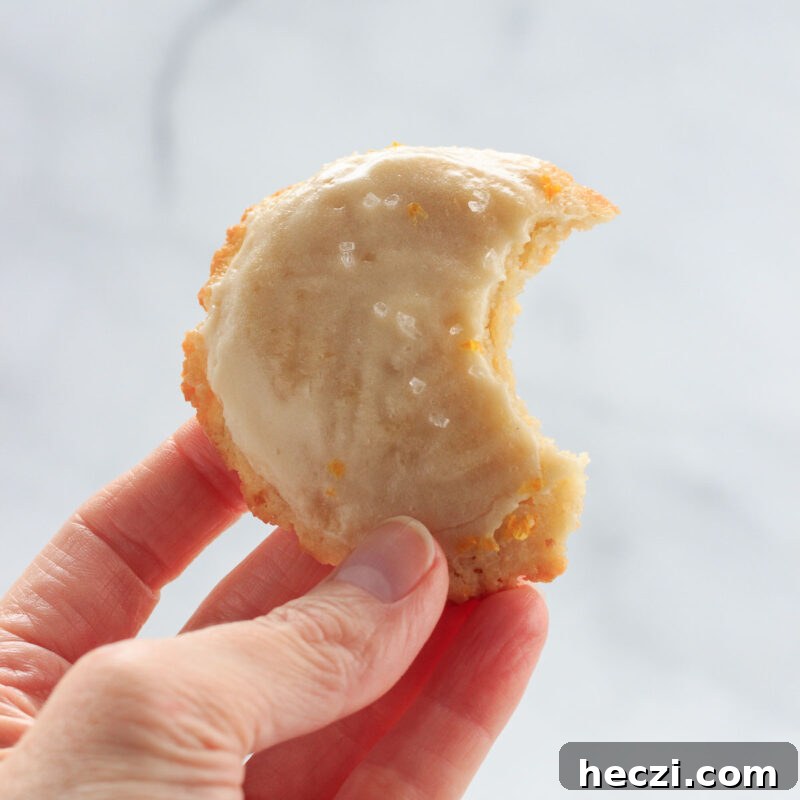 A low carb lemon iced cookie with a bite in it.