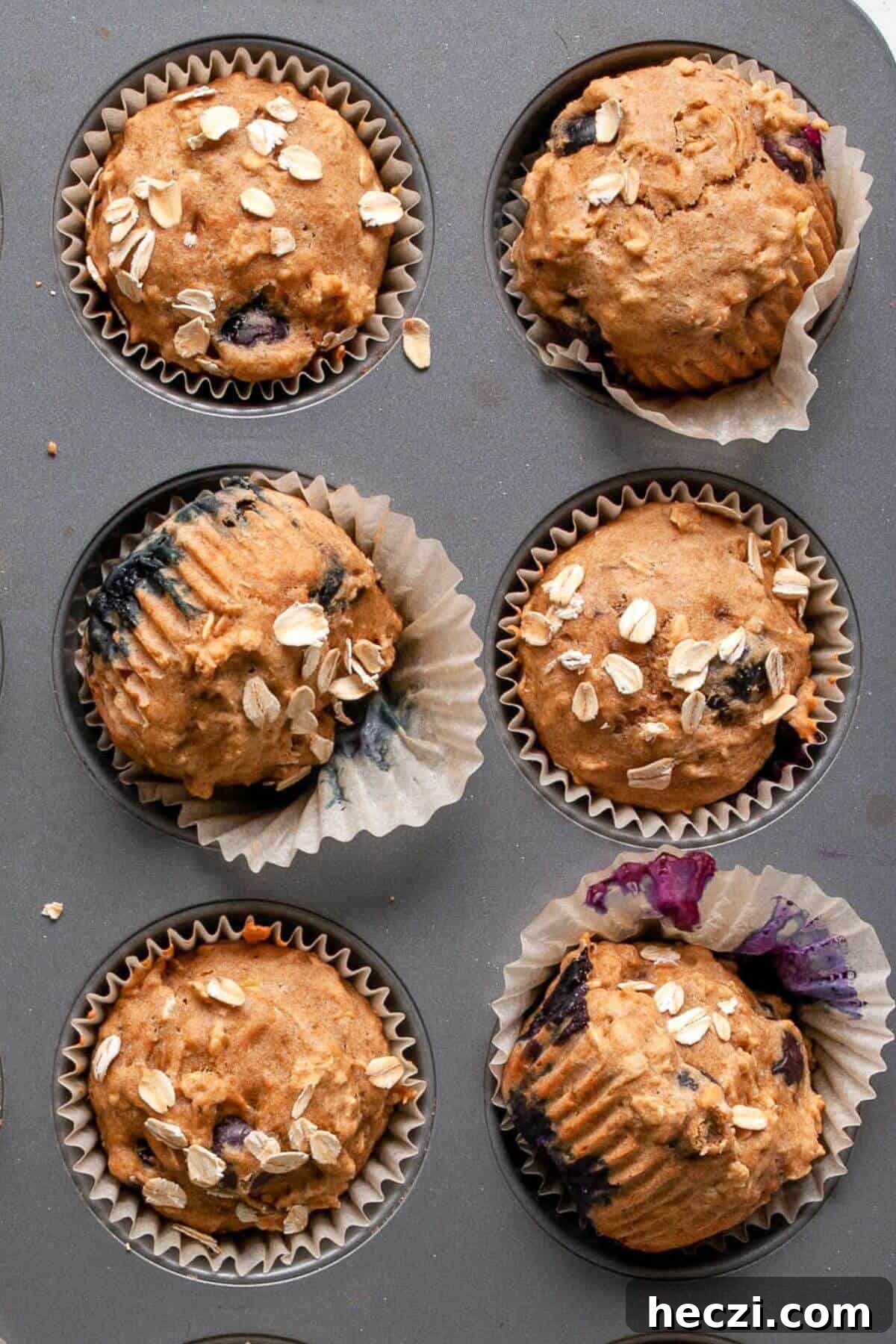 Blueberry Banana Oat Oatmeal Muffins for Breakfast 8 Close up of healthy blueberry banana oatmeal muffins made with oat flour in white muffin liners