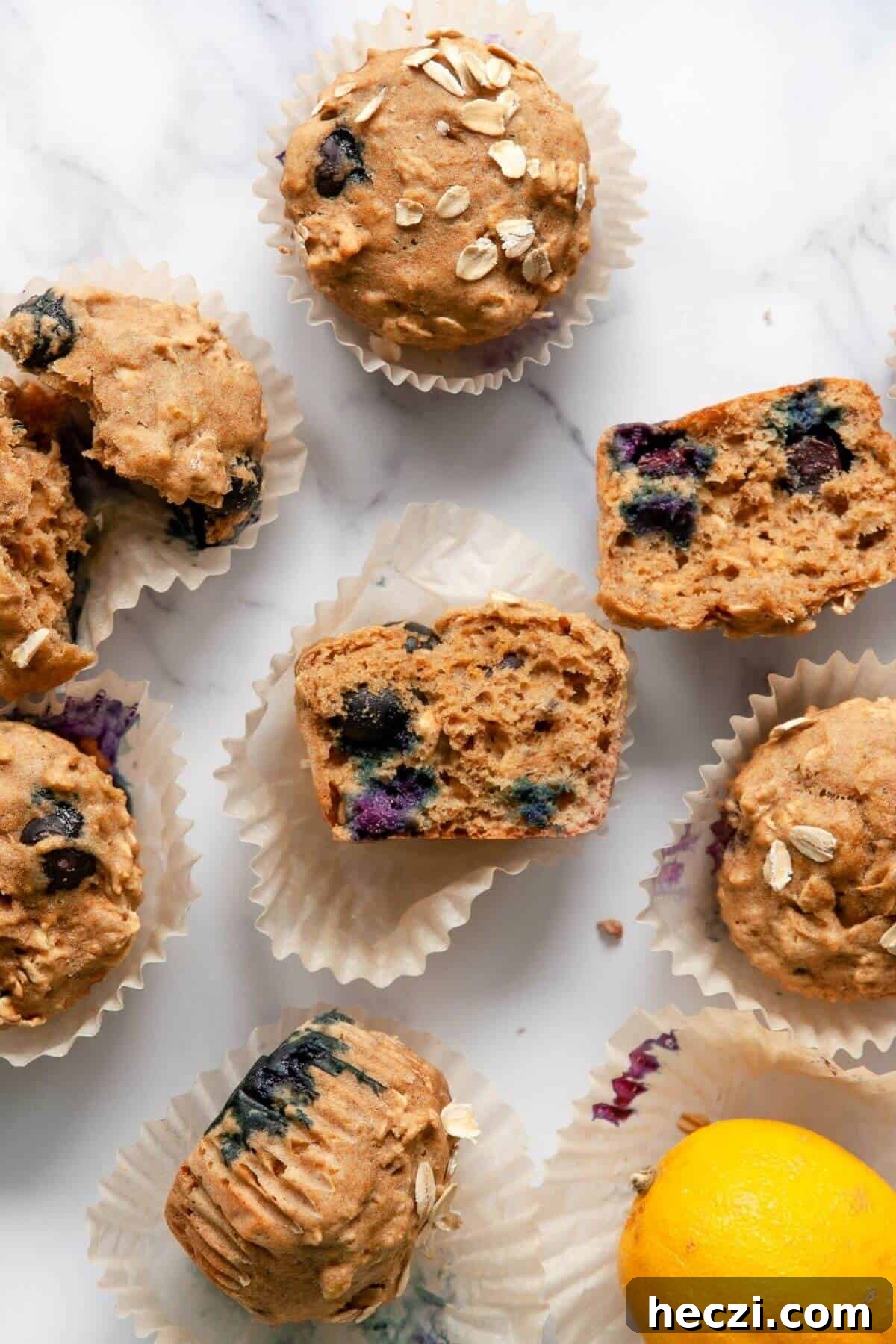 Blueberry Banana Oat Oatmeal Muffins for Breakfast 9 Healthy banana blueberry oatmeal muffins cut in half showing a moist fluffy center with juicy blueberries and oat flour texture.